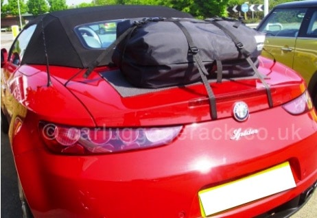 red alfa romeo spider 939 brera convertible with a bootbag original boot rack fitted outside on a sunny day