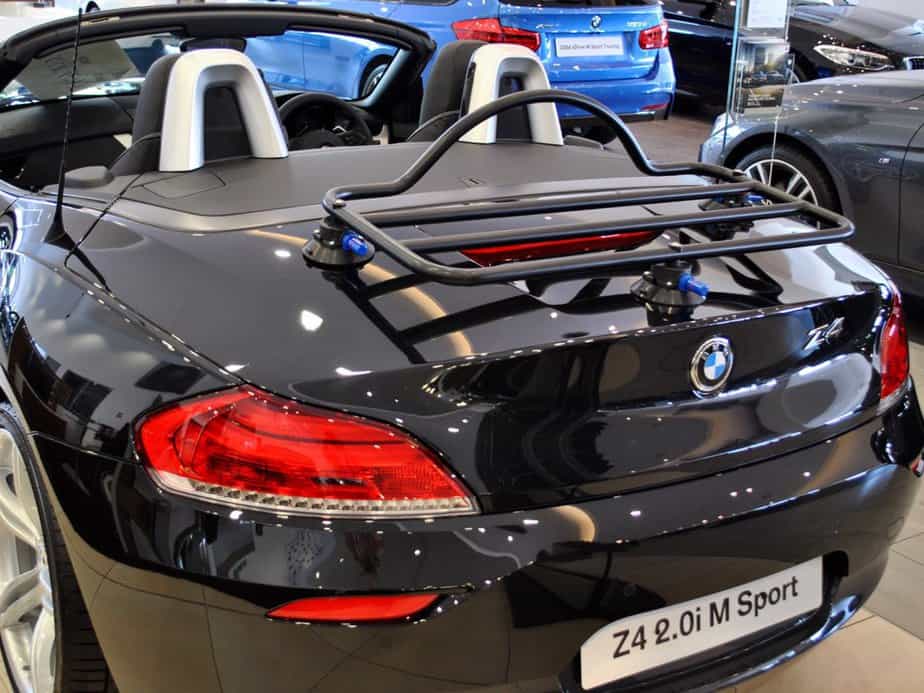 black bmw z4 e89 folding roof model in a bmw showroom with the hood down and a black boot rack fitted