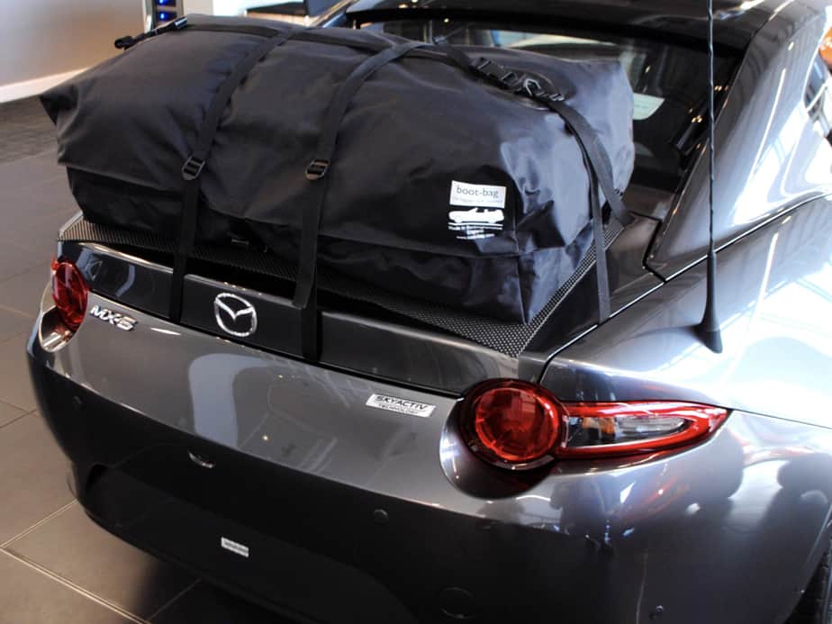 grey mazda mx5 rf with a boot-bag vacation luggage rack fitted in a mazda showroom