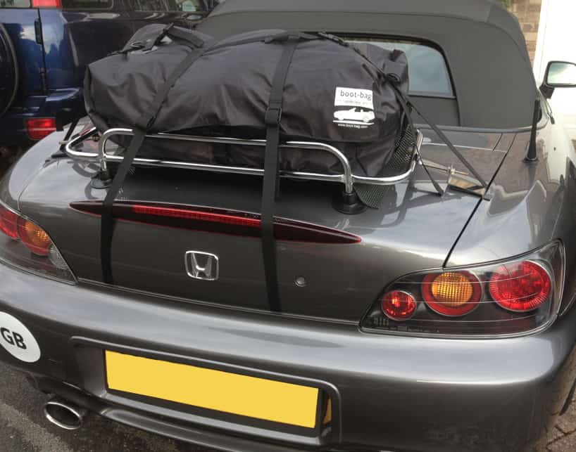 dark grey honda s2000 with a boot rack fitted with a boot-bag on it
