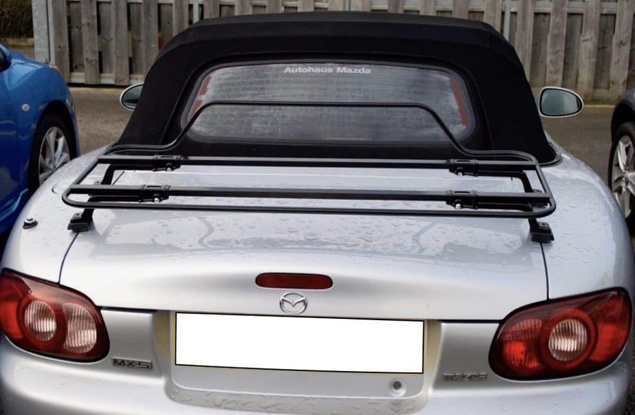 silver mazda mx5 mk1 with a black boot rack fitted on a rainy day