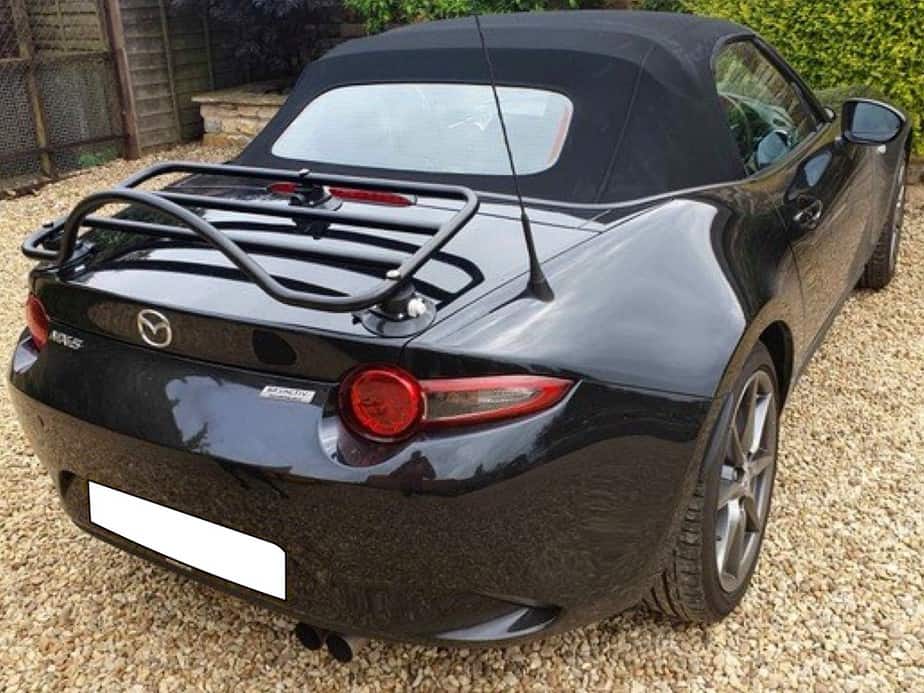 black mazda mx5 mk4 with a revo-rack black boot rack fitted on a gravel drive on a sunny day