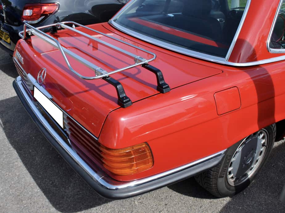 side view of a red mercedes sl r107 450sl with a stainless steel boot rack fitted
