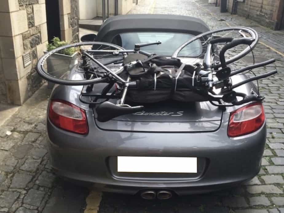 grey porsche boxster 987 with a black luggage rack fitted carrying a bike