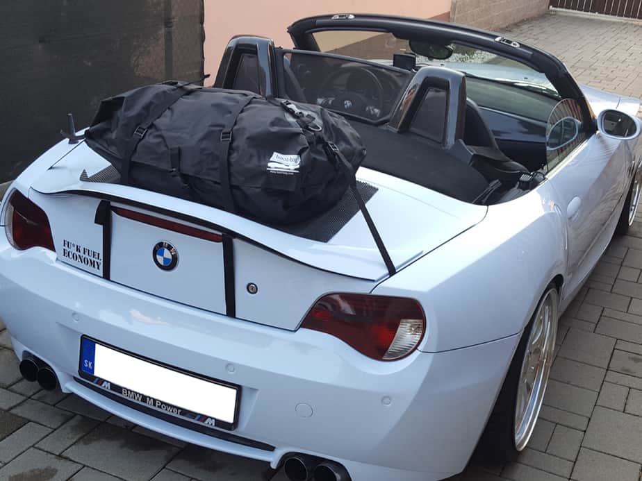 white bmw z4 e85 with a boot-bag fitted to the boot with the hood down.