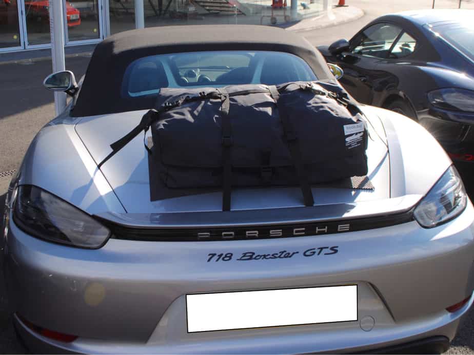 silver 718 porsche boxster gts with a boot-bag original boot rack fitted outside porsche silverstone on a sunny day
