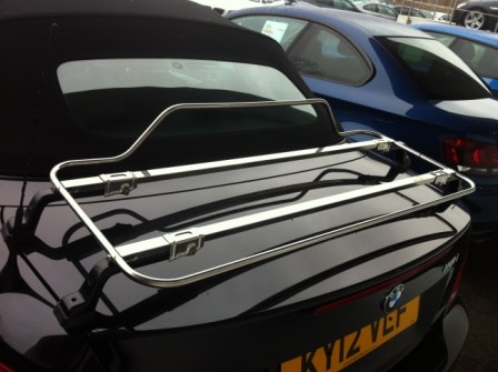 black bmw 1 series with silver boot rack attached in car park