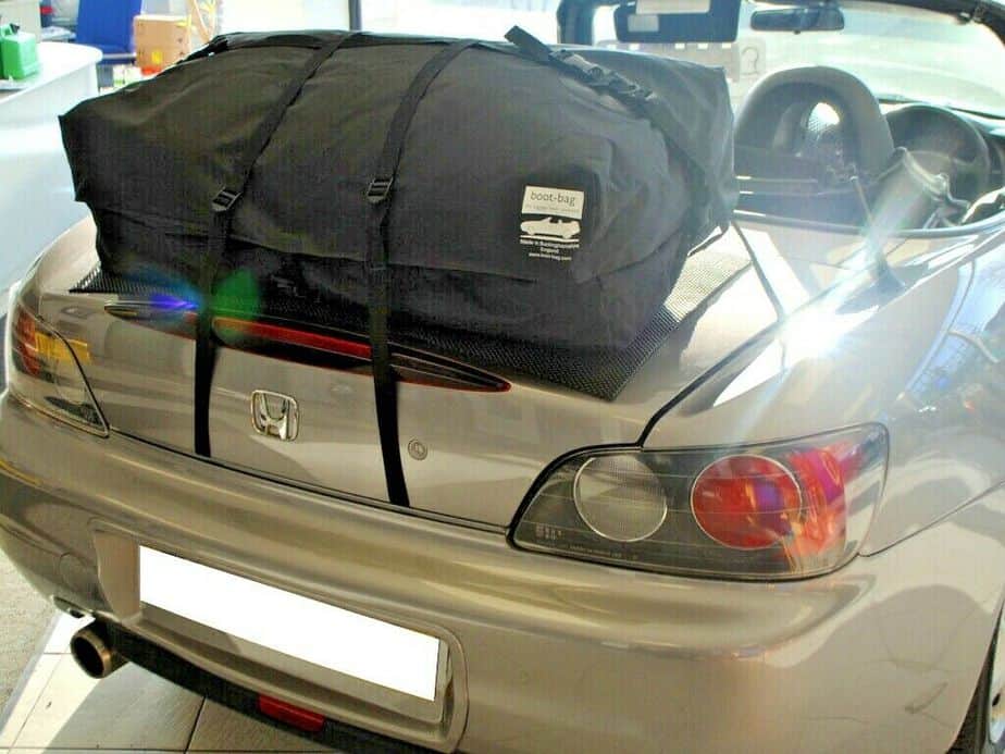 silver honda s2000 in a showroom with the roof down and a boot-bag vacation boot rack fitted