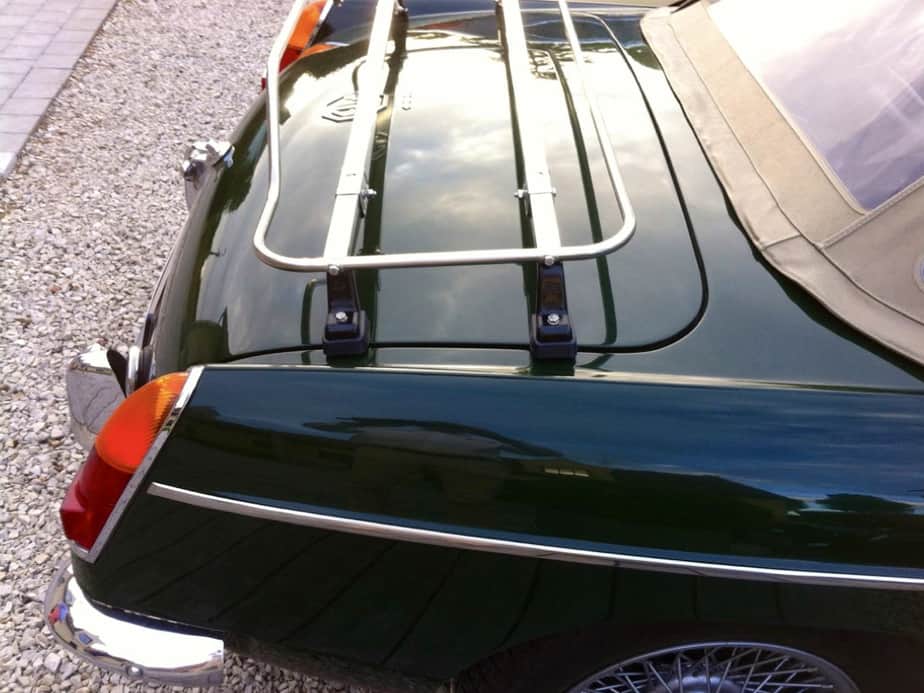 green mgb with a cream hood with a stainless steel boot rack fitted photographed from the side