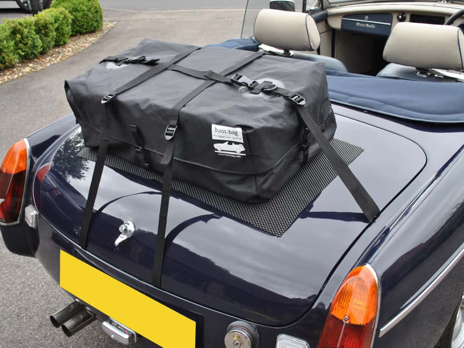 blue mgb with the hood down and a boot-bag luggage rack fitted