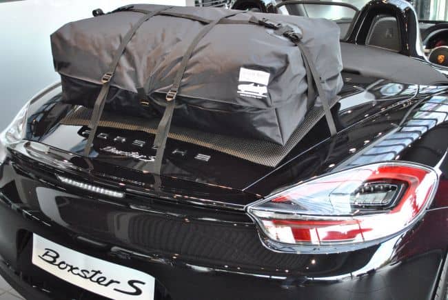 black porsche boxster 981 with the hood down and a boot-bag luggage rack fitted