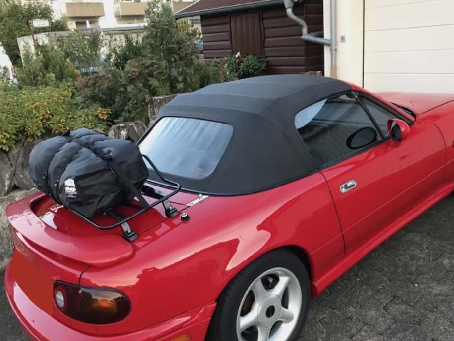 side view of a red mazda mx5 mk1 with a boot rack fitted