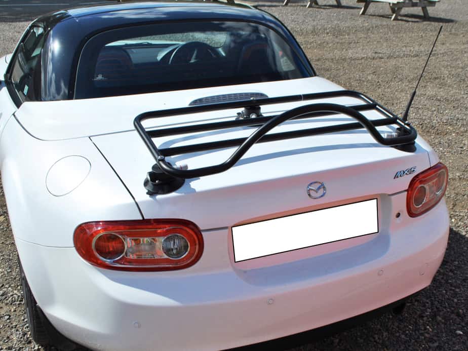 white mazda mx5 mk3 roadster coupe with a black roof and a black boot rack fitted at silverstone next to the track
