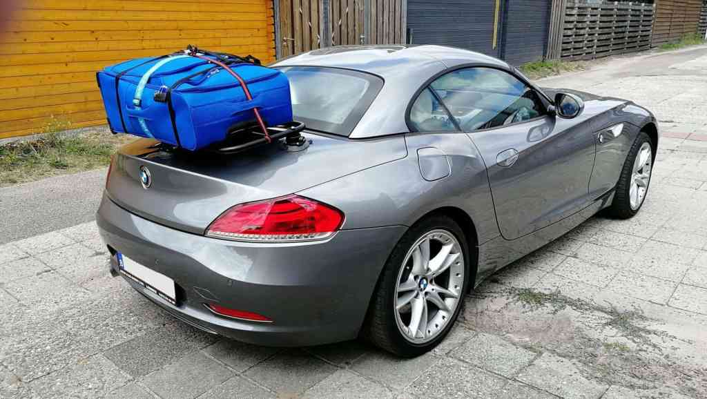 silver bmw z4 e89 with a luggage rack fitted carrying a large blue suitcase